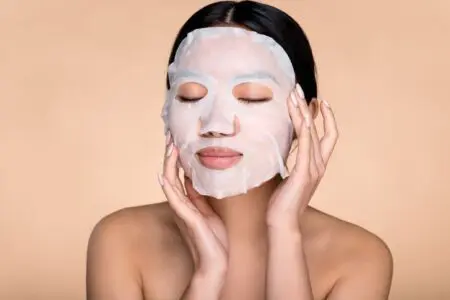 Woman applying a skincare mask to their face.