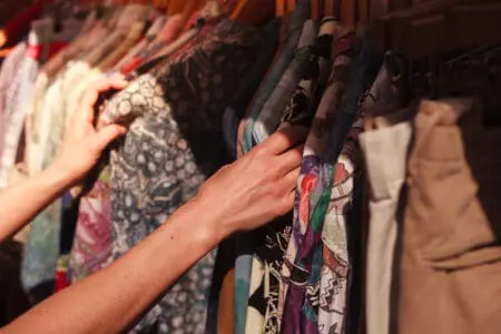 Someone looking through a clothing rack