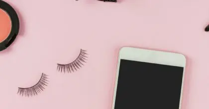 A landscape view of various beauty products on a pink background.