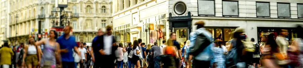 A gathering of shoppers on a busy UK high street.