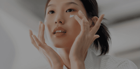Woman applying face cream.
