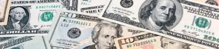 American banknotes in various denominations of American money scattered on top of one another.