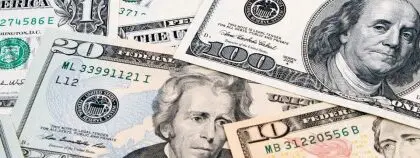 American banknotes in various denominations of American mone scattered on top of one another.