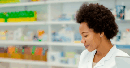A lady speaking to another lady over the counter of a pharmacy