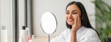 Woman examines her skin in the mirror