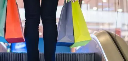 Shopper, carrying several colourful shopping bags.