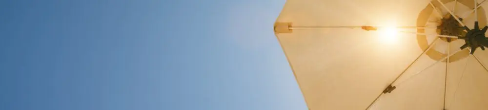 Bright sun shines through a beige umbrella