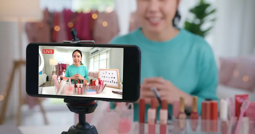 Beauty-Influencerin, die ein Video mit dem Handy aufzeichnet.