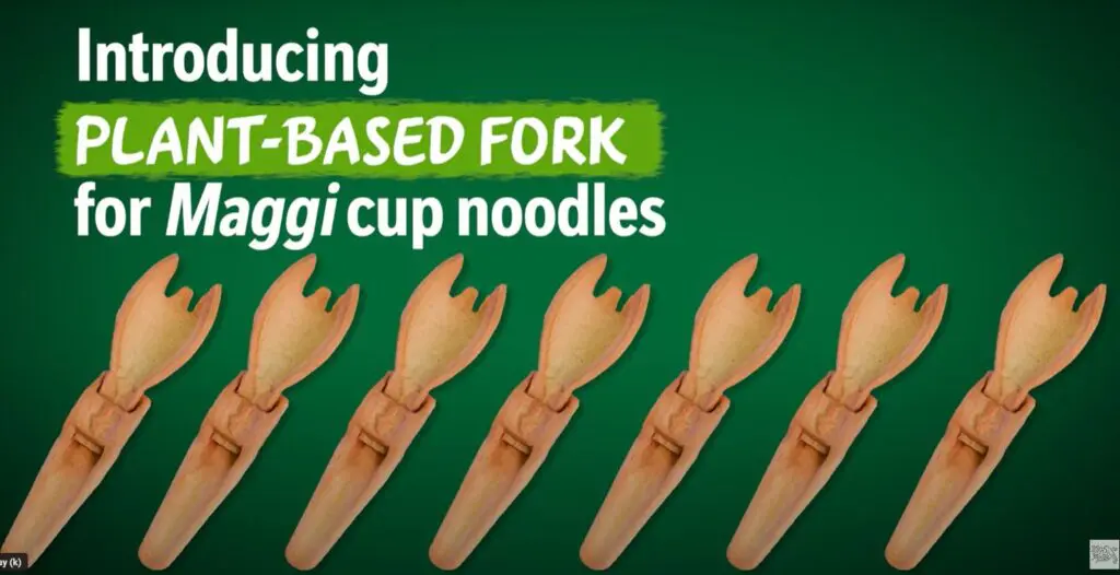 Screenshot des Clips von Maggi zur Vorstellung ihrer essbaren Gabel, mit Produktbildern der gleichen Gabel nebeneinander auf grünem Hintergrund. Aufschrift oben links: "Einführung der pflanzlichen Gabel für Maggi Cup Noodles"