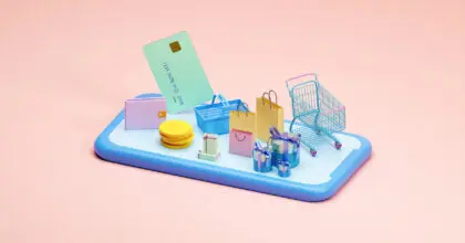 Smartphone mit Einkaufswagen und Shopping-Tüten.