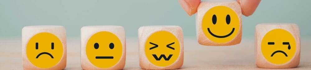 5 wooden blocks with different yellow emotion faces on