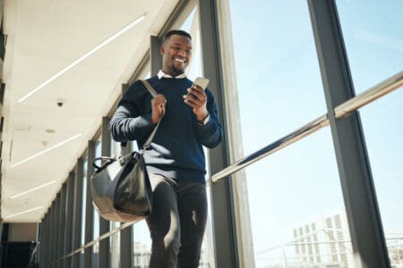 Man walking through airport on his phone.