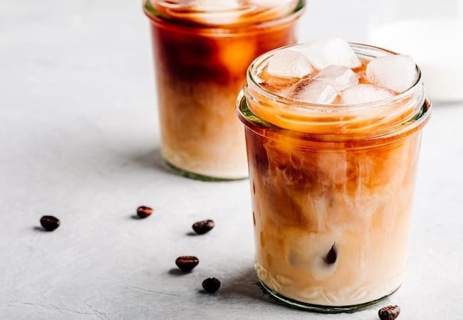 Gen Z Snacking Trends: Nightfood Sleep Friendly Cold Brew Coffee Latte in glass jar on a grey background.