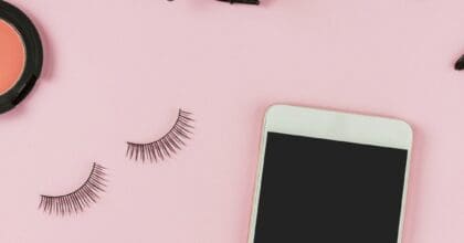 A landscape view of various beauty products on a pink background.