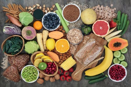 High fibre super food with whole grain bread loaf and rolls, fruit, vegetables, whole wheat pasta, cereals, seeds and nuts.