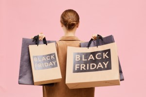 Women holds several shopping bags that say 