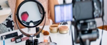 Table is scattered with various beauty products.