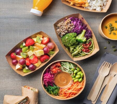 Food served in cardboard bowls and wooden cutlery on the side.