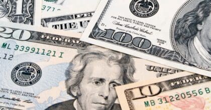 American banknotes in various denominations of American mone scattered on top of one another.