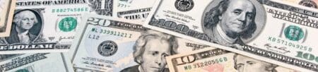 American banknotes in various denominations of American mone scattered on top of one another.