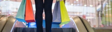 Shopper, carrying several colourful shopping bags.
