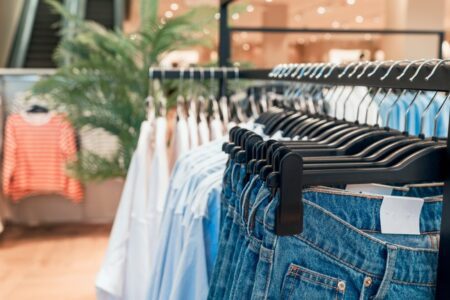 Close up of clothing rails displaying items of clothing in a shop.