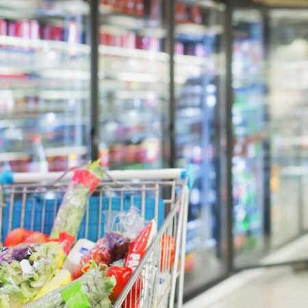 Lebensmittel im Regal und Einkaufswagen im Supermarkt